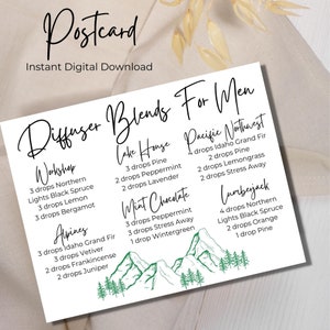 May include: A white postcard with a green mountain illustration and text that reads "Diffuser Blends For Men". The postcard lists different diffuser blends with names like "Workshop", "Lake House", "Pacific Northwest", "Mint Chocolate", "Alpines", and "Lumberjack". Each blend lists the essential oils and number of drops needed for each.