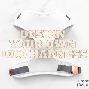 Op de afbeelding: Witte hondentuig met grijze en roségouden details. De tekst "DESIGN YOUR OWN DOG HARNESS" staat op het tuig. De voorkant (buikzijde) is zichtbaar.
