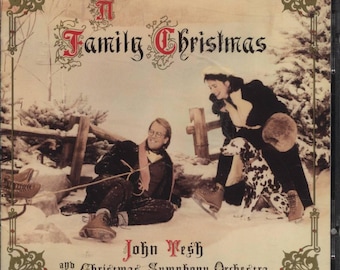 May include: A Family Christmas CD cover featuring a snowy scene with two people, a Dalmatian dog, and the text "A Family Christmas" in ornate lettering. The artist is John Tesh and the Christmas Symphony Orchestra.