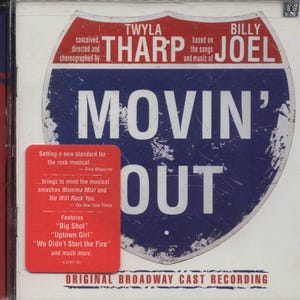May include: A red and blue road sign with the text "MOVIN' OUT" in white. The sign is surrounded by a white background with the text "TWYLA THARP BILLY JOEL" and "ORIGINAL BROADWAY CAST RECORDING".