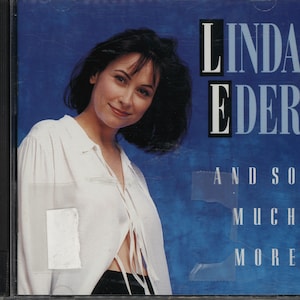 May include: CD case featuring Linda Eder with the text "LINDA EDER" in white and black, and "AND SO MUCH MORE" in white. The background is a gradient of blue. Eder is wearing a white blouse.