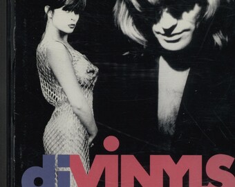 Puede incluir: Portada del CD de la banda Divinyls. La portada presenta una imagen en blanco y negro de una mujer con un vestido de red y un hombre con el pelo largo. El nombre de la banda está en letras rojas y azules.