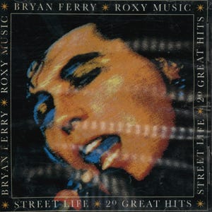 May include: CD case for "Street Life 20 Great Hits" by Bryan Ferry and Roxy Music. The cover features a close-up of a person's face with orange, blue, and black tones. The text "BRYAN FERRY ROXY MUSIC" and "STREET LIFE 2º GREAT HITS" are visible.