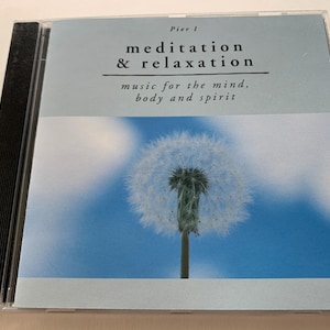 May include: CD case with the title "meditation & relaxation" and the tagline "music for the mind, body and spirit." The cover art features a close-up of a dandelion against a blue sky background.