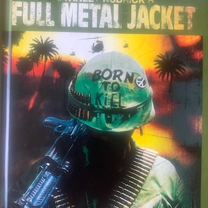 May include: Blu-ray disc cover for Stanley Kubrick's "Full Metal Jacket." The cover shows a soldier in a green helmet with the words "BORN TO KILL" and a peace symbol. The soldier is holding a machine gun, with a backdrop of palm trees and helicopters.