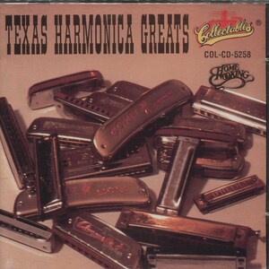 May include: A CD case featuring a collection of harmonicas. The cover reads "TEXAS HARMONICA GREATS" in bold, dark text. The harmonicas are various sizes and colors, with some bearing brand names like "COMET" and "Hohner". The overall color scheme is brown and gold.