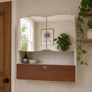 May include: A wall-mounted medicine cabinet featuring two arched mirror doors, an open storage shelf with a small checkered pattern back panel, and a lower cabinet section with a dark brown wood-grain finish and a single silver metal handle.