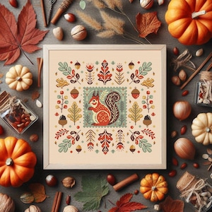 Peut inclure: Motif de point de croix représentant un écureuil mignon entouré de feuilles d'automne, de glands et de baies. Le motif est encadré dans un cadre en bois clair et placé sur un fond rustique.