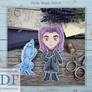 May include: Cross stitch pattern PDF for a character with purple hair and a blue wolf. The pattern is titled "Daily Magic Stitch".
