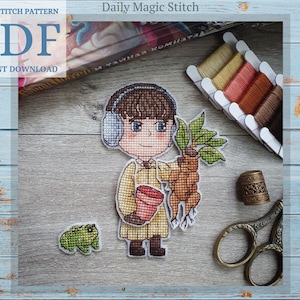 May include: Cross stitch pattern PDF instant download of a cartoon character wearing headphones and holding a potted plant. The character is wearing a yellow jacket and brown pants. The pattern includes a frog and a spool of thread.