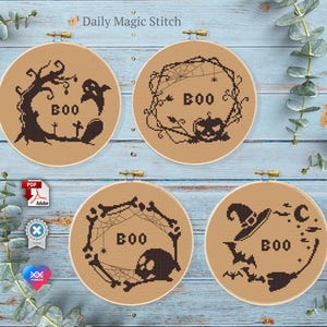 May include: Four brown embroidery hoops with black Halloween-themed designs. The designs include a ghost, a pumpkin, a skull, and a witch's hat. Each hoop has the word "BOO" written on it.