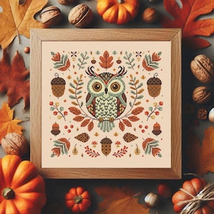 Peut inclure: Un motif de point de croix représentant un hibou stylisé entouré de feuilles d'automne, de glands et de baies. Le hibou est représenté dans des tons de brun, de vert et de blanc, avec un design fantaisiste.