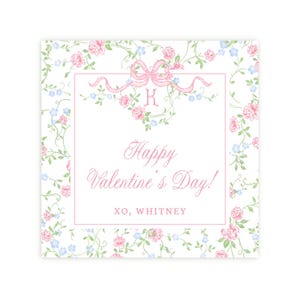 Könnte beinhalten: Eine weiße quadratische Karte mit einem rosafarbenen Blumenmuster. Die Karte hat einen weißen Rand mit einem rosafarbenen Band und dem Buchstaben "K" in der Mitte. Der Text "Happy Valentine's Day! XO, WHITNEY" ist in rosa gedruckt.