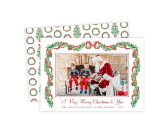 Könnte beinhalten: Eine rechteckige Weihnachtsgrußkarte mit einem zentralen Foto von zwei Kindern, die mit dem Weihnachtsmann sitzen. Die Karte ist mit einer Aquarellillustration aus grünen Girlanden und roten Bändern gerahmt, mit dem Text A Very Merry Christmas to You.