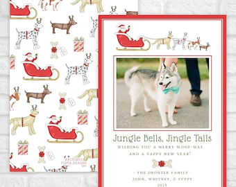 May include: A holiday card featuring a pattern of Santa in a sleigh with dogs wearing reindeer antlers, gift boxes, and bones. The card includes a photo of a husky wearing a teal bowtie, with the text Jungle Bells, Jingle Tails, Wishing you a merry woof-mas and a yappy new year, The Dronzek Family, John, Whitney, & Puppy 2023.