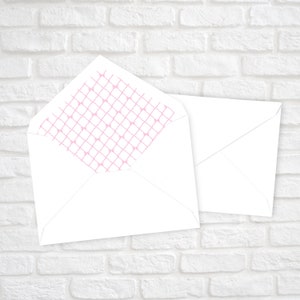 May include: Two white envelopes, one with a pink patterned flap. The pattern is a grid of small pink circles connected by thin lines.