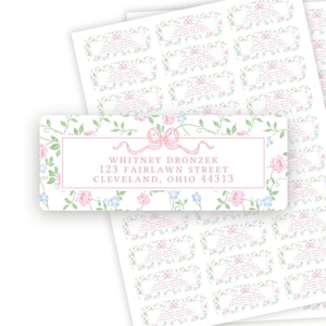 May include: Sheets of address labels with a floral design. Each label features a pink bow and a border of pink, blue, and green flowers. The labels include the name "Whitney Dronzek" and an address.