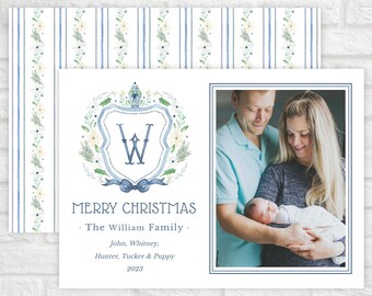 May include: A rectangular holiday greeting card featuring a blue watercolor crest with the letter W, a photo of a family, and the text MERRY CHRISTMAS, The William Family, John, Whitney, Hunter, Tucker & Puppy, 2023. The card has a blue striped border.