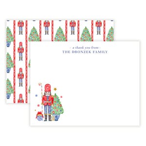 May include: A set of thank you note cards featuring a watercolor illustration of a nutcracker holding a candy cane and standing next to a Christmas tree. The cards have a red and white striped pattern with nutcrackers and Christmas trees on the back. The text "a thank you from - THE DRONZEK FAMILY" is printed on the front of the cards.