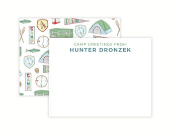 Puede incluir: Juego de papelería con un bloc de notas blanco con el texto turquesa "CAMP GREETINGS FROM HUNTER DRONZEK". El papel de respaldo estampado presenta ilustraciones temáticas de campamento en verde, rojo y amarillo, incluyendo tiendas de campaña, brújulas y remos.