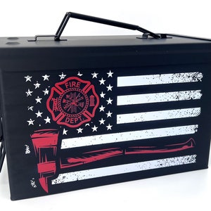 May include: Black metal ammo can with a distressed American flag design featuring a red firefighter's axe and a red firefighter's cross with the words "FIRE DEPT."