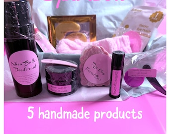 May include: A Spa Box containing 5 handmade products: a Shea Butter Deodorant stick, a Rose Water Face Cream jar with a pink spatula, a Rose Clay Facial Bar, a Caffeine Eye Serum, and a Blueberry Lip Scrub. Includes a pink headband and eye mask.