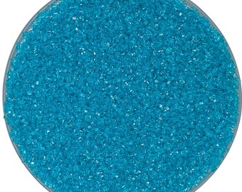 May include: A close-up view of a bowl filled with turquoise blue sugar crystals.