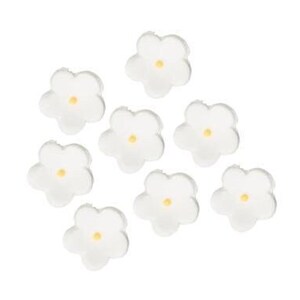 Op de afbeelding: Acht kleine, witte, bloemvormige versieringen met gele centra zijn verspreid op een witte achtergrond. De bloemblaadjes zijn afgerond en het algehele ontwerp is eenvoudig en delicaat. Voor knutselen of decoraties.