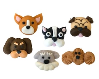 Può includere: Sei diversi topper per torte a forma di testa di cane realizzati in pasta di zucchero. I topper sono di vari colori, tra cui marrone, nero, bianco e grigio. I volti dei cani sono tutti sorridenti e hanno espressioni diverse.