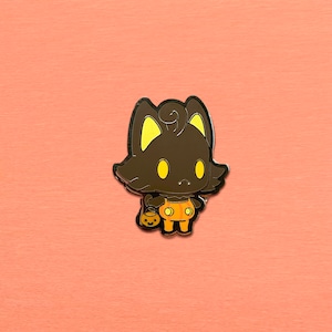 May include: A black cat wearing an orange and black Halloween costume with a pumpkin bucket. The cat has yellow eyes and a black nose. The cat is holding a small pumpkin bucket in its right paw.