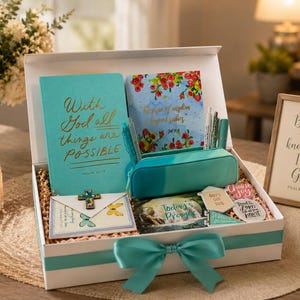 May include: A white gift box tied with a teal ribbon containing a teal journal with the text With God all things are POSSIBLE, a floral notebook, a teal pencil case with pens, a cross ornament, a prayer card, and several small stickers.