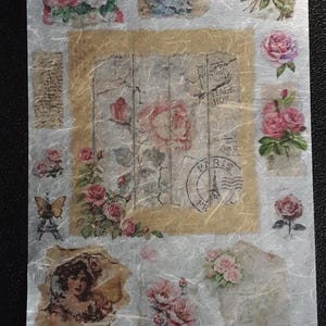 May include: A sheet of decorative stickers featuring vintage-style floral designs. The stickers include images of roses, butterflies, and a woman, with a central design resembling aged paper. The text "PARIS" is visible.