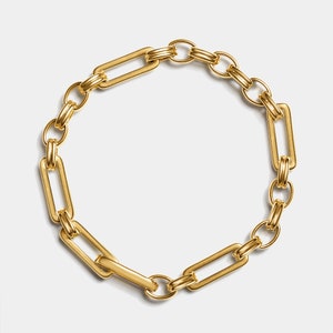 May include: A gold chain bracelet with large, linked, rectangular links.