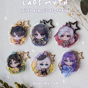 May include: Six foiled acrylic keychains featuring anime-style characters. Each keychain has a different character design with vibrant colors and gold accents. The text "LAOS MYTH" and "FOILED ACRYLIC KEYCHAINS" are visible.