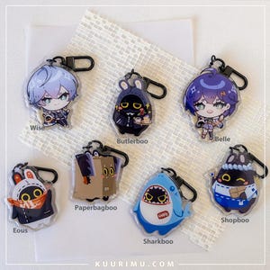 Może przedstawiać: Kolekcja akrylowych breloków z postaciami w stylu anime. Projekty obejmują postać z niebieskimi włosami, czarną postać w kapturze, postać z fioletowymi włosami, postać w stroju królika, postać w kartonowym pudełku, rekina i postać w niebieskim fartuchu.