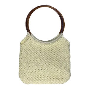 以下が含まれることがあります： クリーム色のマクラメハンドバッグ。丸みを帯びた形状で、濃い茶色の木製ハンドルが2つ付いています。バッグは織り込まれたテクスチャで、シンプルでエレガントなデザインです。丸いハンドルがバッグに自然な暖かさを加えています。