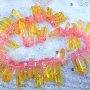 Peut inclure: Un brin de perles de cristal rose et jaune. Les perles sont facettées et ont une apparence translucide. Les perles sont enfilées sur un fil transparent.