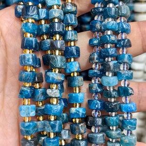 May include: A strand of blue and gold gemstone beads. The beads are square shaped and have a mottled blue color. The beads are separated by gold spacers.