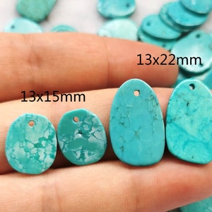 May include: Turquoise gemstone pendants in three sizes: 13x15mm, 13x22mm, and 13x15mm. The pendants are oval shaped and have a hole drilled through the top for hanging.