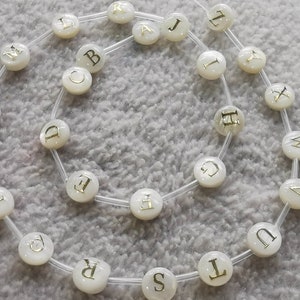 Venta al por mayor 26pcs Natural white Shell Beads, MOP Shell with Gold Alphabet Bead- Puff Spacer - Double Sided Letter - Puff Round 8mm