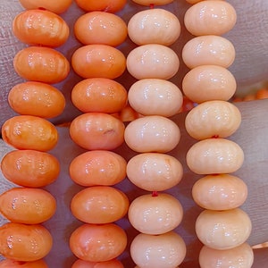 Puede incluir: Tres hebras de cuentas de coral, una hebra es naranja, otra es naranja claro y la última hebra es rosa. Las cuentas son redondas y lisas.