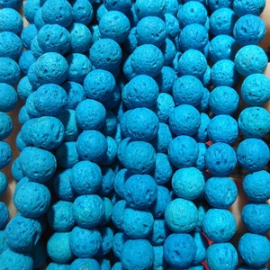 May include: A strand of bright blue lava rock beads. The beads are round and have a porous texture.
