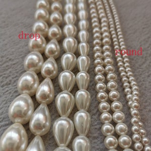 May include: Two strands of white pearl beads, one with round beads and the other with teardrop shaped beads. The strands are labelled "round" and "drop".