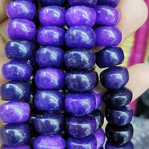 May include: A strand of purple and dark blue gemstone beads. The beads are round and have a smooth, polished finish.