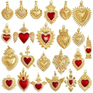 May include: A collection of 20 gold-tone pendants featuring red and white enamel hearts with intricate details. The pendants are adorned with various designs, including crowns, wings, and crosses.