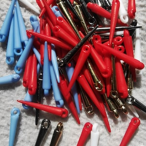 May include: A large assortment of colourful plastic spikes with metal loops. The spikes are in red, blue, white, black, and gold.