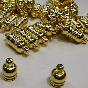 May include: A group of gold-toned metal clasps, some with a textured surface, and two smaller gold-toned metal caps.