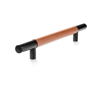 Puede incluir: Tirador de armario de cuero negro y marrón con forma cilíndrica.