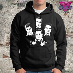 Puede incluir: Sudadera con capucha negra con un gráfico blanco de cuatro caras de hombres. Las caras están dispuestas en forma de diamante.