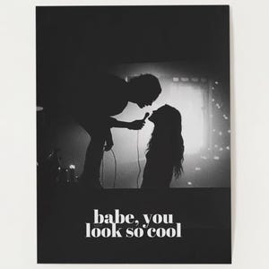 Puede incluir: Foto en blanco y negro de una pareja silueteada contra un fondo brillante. El hombre sostiene un micrófono y la mujer lo mira. El texto "babe, you look so cool" está impreso debajo de la imagen. El texto "matcha milk studio" está impreso debajo del texto.
